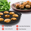 Black griddle with cooked food, fresh herbs, and a plate of snacks on a white background.