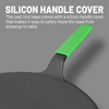 Black tawa with green silicon handle cover on a gray background