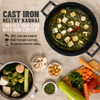 Cast iron kadhai with food and ingredients on a wooden surface