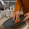 Person cleaning a black pan with a green sponge, accompanied by cleaning process instructions.