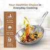 Stainless steel frying pan with cooked vegetables and a brown informational panel on a light background.