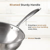 Stainless steel frying pan with riveted handle on a light background