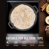 Flatbread cooking on a black skillet with a wooden background and food items.