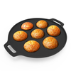 Black round baking pan with seven golden-brown baked goods on a white background