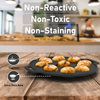 Black cast iron pan with baked goods on a wooden surface, kitchen background.