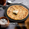 Pre-seasoned cast iron skillet with a flatbread and butter, surrounded by kitchen utensils.