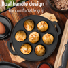 Black non-stick pan with food on a wooden surface, featuring dual handles for comfortable grip.