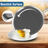 Frying pan with nonstick surface showing eggs on a plate, on a wooden table.