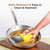 Stainless steel frying pan being cleaned easily with sponge showing stain-resistant surface