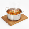 Stainless steel pot with stew on a wooden trivet on a white background
