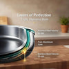 Stainless steel pot with text highlighting material layers on a wooden surface.